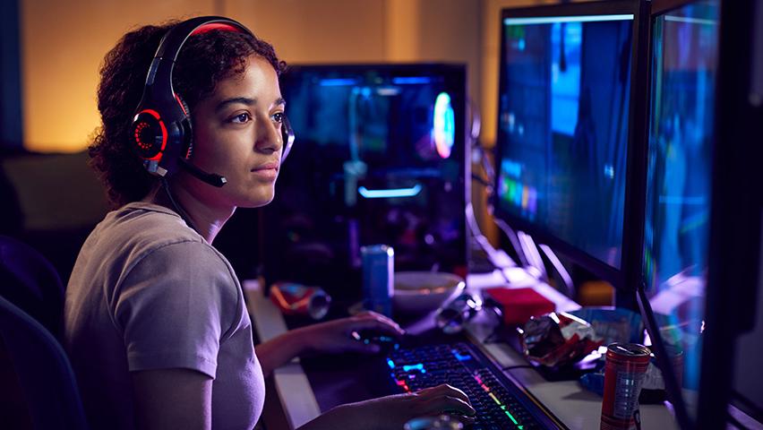 Girl wearing headset and uses computers for gaming